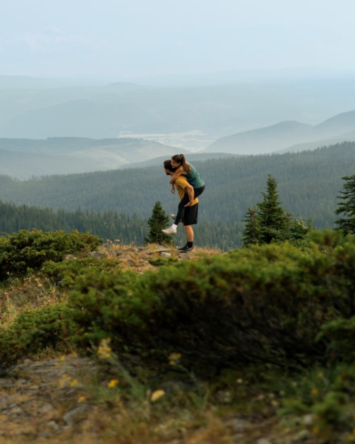 Couple taking in the mountain view from a summer hiking trail above Silver Star